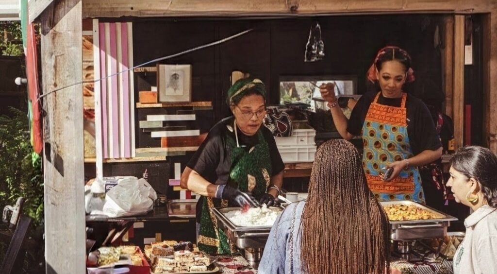 Het team van Nanana's Kitchen schept gerechten op in de kraam